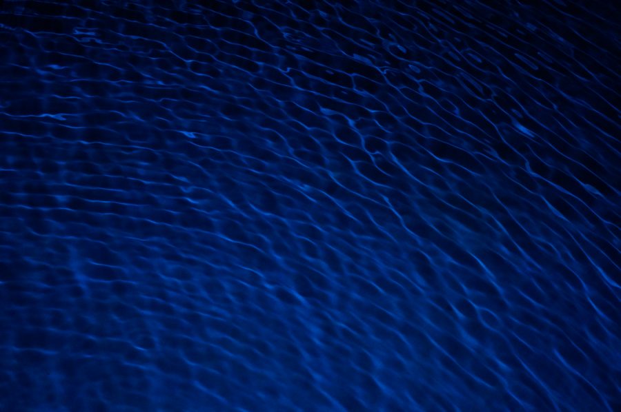 Diagonal currents of light rippling across dark blue water